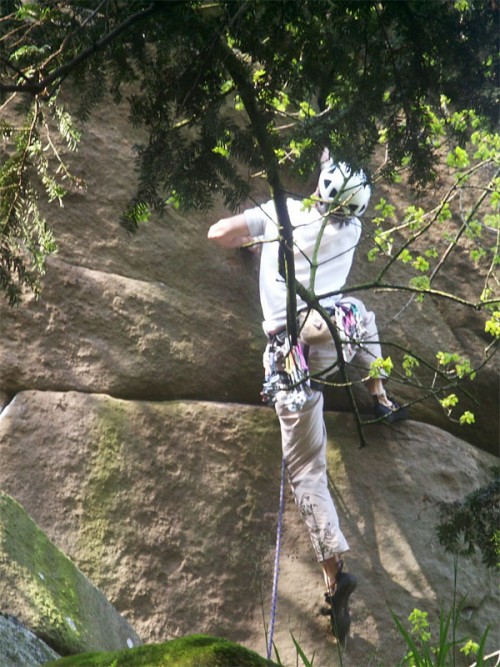 Rock climber above the Hermits Cave on Cratcliff Tor
