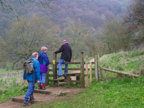 Walkers crossing a stile from White Lodge into Deep Dale